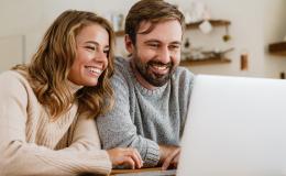 Małżeństwo przed laptopem z uśmiechem