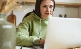 kobieta w zielonym dresie, pulchna, przed laptopem