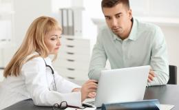 pacjent i lekarka patrzą w laptop