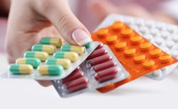 dłoń kobiety z blistrami leków