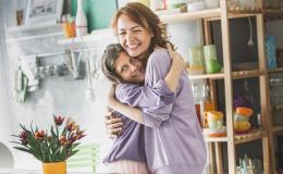 Matka obejmująca córkę, z tyłu tulipany