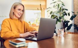 Kobieta w żołtej bluzie przed komputerem