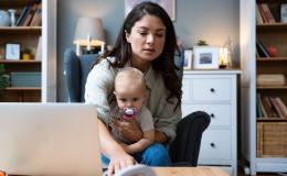matka z dzieckiem na kolanach przed laptopem