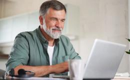 pan z siwą brodą przed komputerem