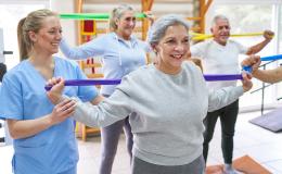 Seniorzy ćwiczący z taśmami