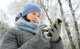 dziewczyna w czapce i kurtce na spacerze z komórką w reku