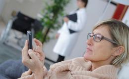 Pani w przychodni patrzy na komórkę