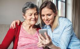Mloda kobieta pokazuje starszej cos na telefonie