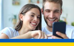 młoda para patrzy na komórkę, którą trzyma chłopak ukr