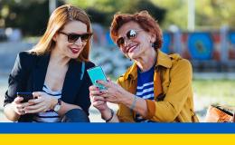 dwie panie w średnim wieku z komórkami, coś sobie tłumaczą ukr