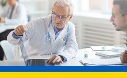 Lekarz pokazuje coś pacjentowi w komputerze ukr