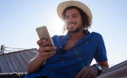 młody meżczyzna w kapeluszu z komórka