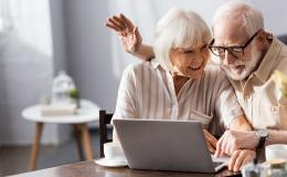 starsza para przy laptopie na kanapie