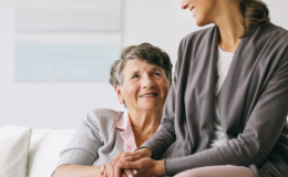 Dwie kobiety, starsza i młodsza,trzymają się za ręce