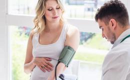 lekarz bada cisnienie ciężarnej kobiecie