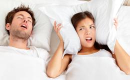 mężczyzna chrapie, obok kobieta poduszką zakrywa uszy