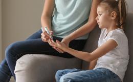 dziewczynka ma badanie glukometrem