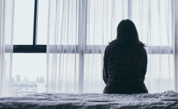 kobieta siedzi w ciemnym pokoju