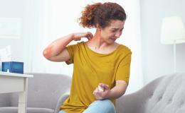 Kobieta drapie czrwone miejsce na szyi