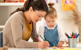 Kobieta rysuje z dziewczynką.