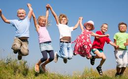 dzieci radośnie skaczą na łące
