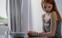 kobieta siedzi przy pustym talerzu