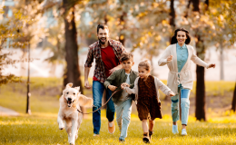 Rodzina biegnie po parku z psem