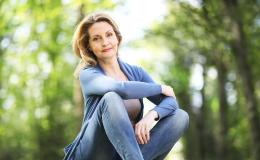 Kobieta siedzi na trawie w lesie