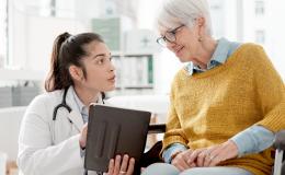 lekarka rozmawia ze starszą kobietą na wózku