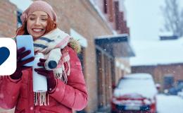 dziewczyna opatulona, w tle zima w mieście, ona z komorka