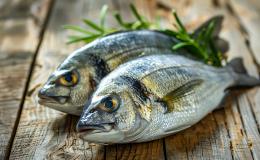 dwie ryby leżą na drewnianym stole