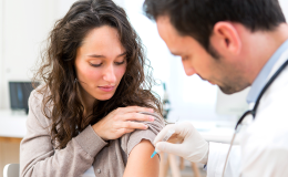 lekarz szczepi kobietę