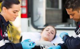 Dwoje ratowników z chorą na noszach