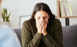 Młoda kobieta trzyma twarz w dłoniach