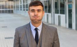 Mężczyzna w garniturze wydyma policzki.