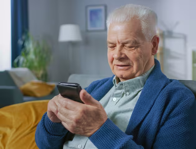starszy pan patrzy na telefon