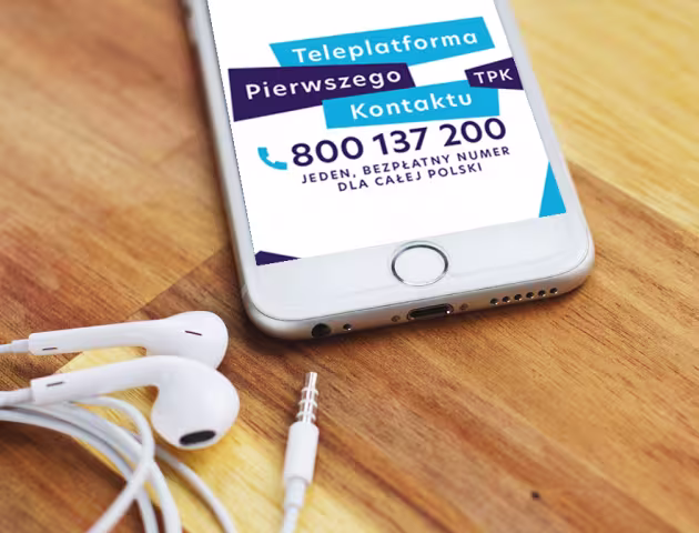Leżący na stole telefon z widocznymi na ekranie numerem Teleplatformy Pierwszego Kontaktu