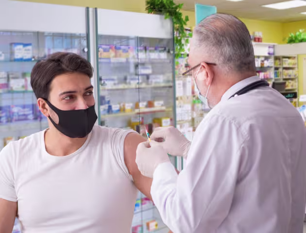 młody mężczyzna jest szczepiony przez farmaceutę