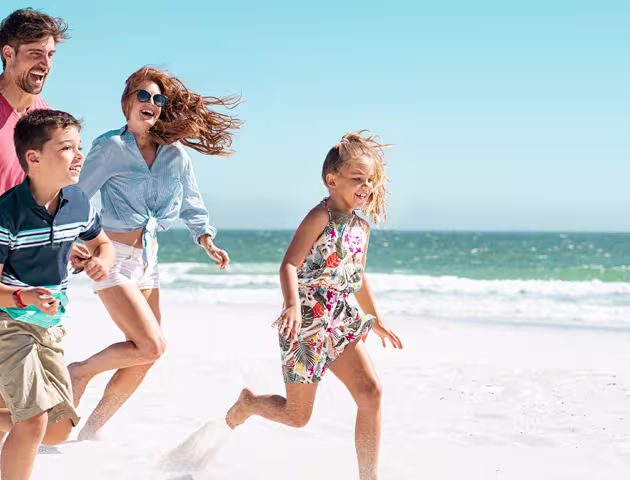 Rodzina biegnie po plaży