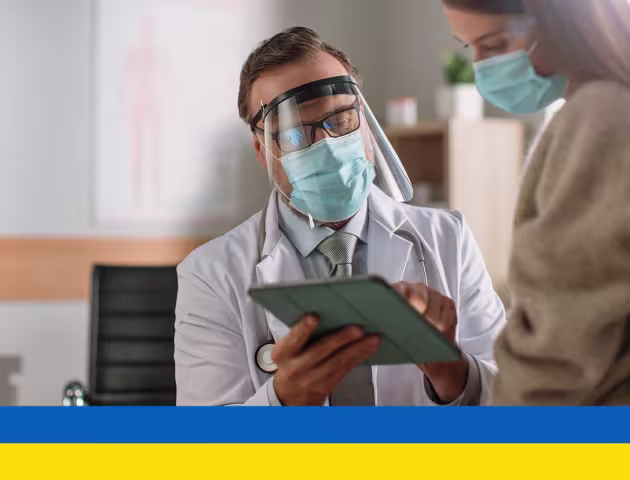 Lekarz pokazuje coś pacjentce na tablecie