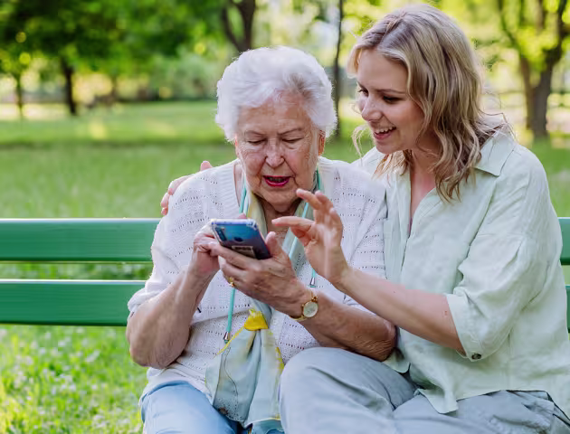 Mloda dziewczyna pokazuje seniorce coś na komórce
