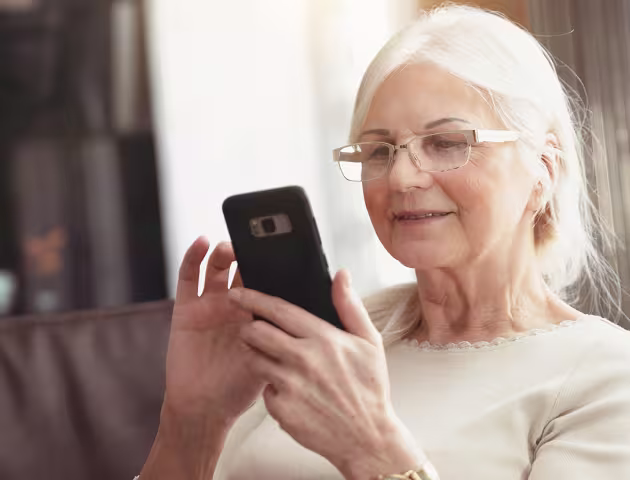 siwa pani z uśmiechem patrzy na telefon