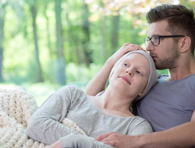 kobieta z chustką na głowie i mężczyzna na sofie