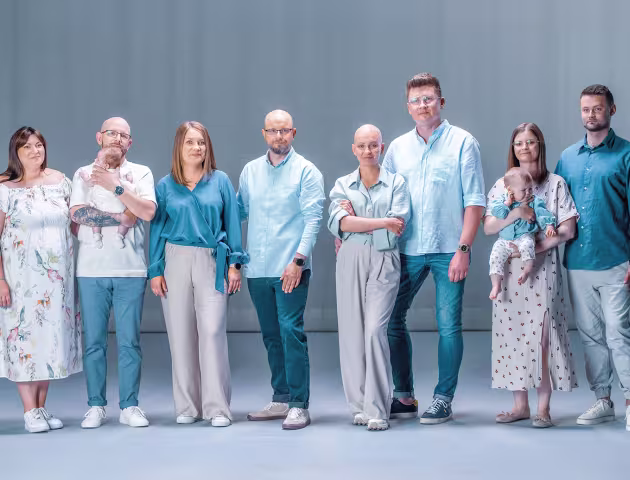grupa osób w różnym wieku, z dziećmi i bez, w tym kobieta bez wlosów