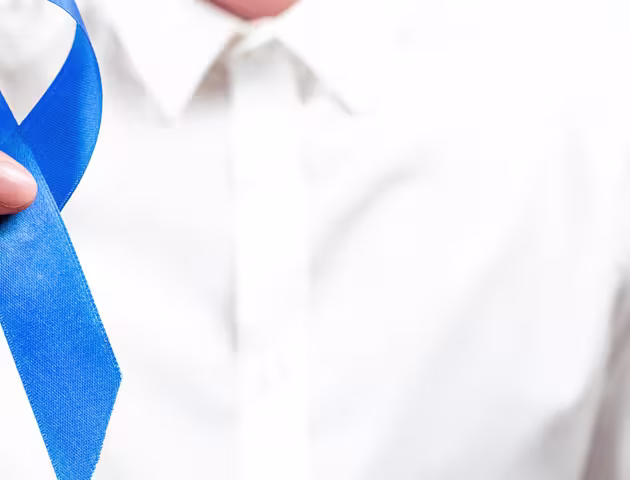 mężczyzna trzyma niebieską wstążeczkę