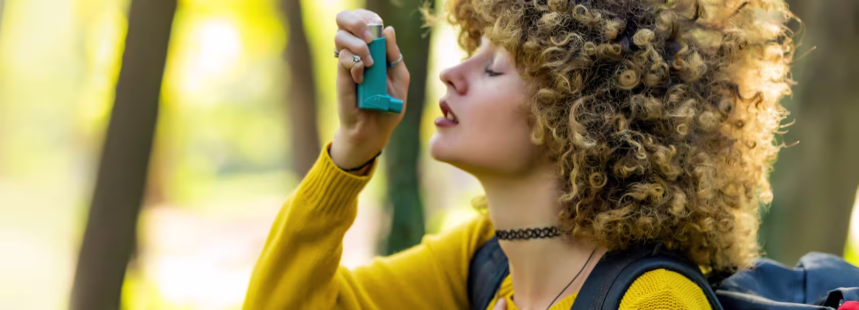 Dziewczyna z kręconymi włosami trzyma inhalator