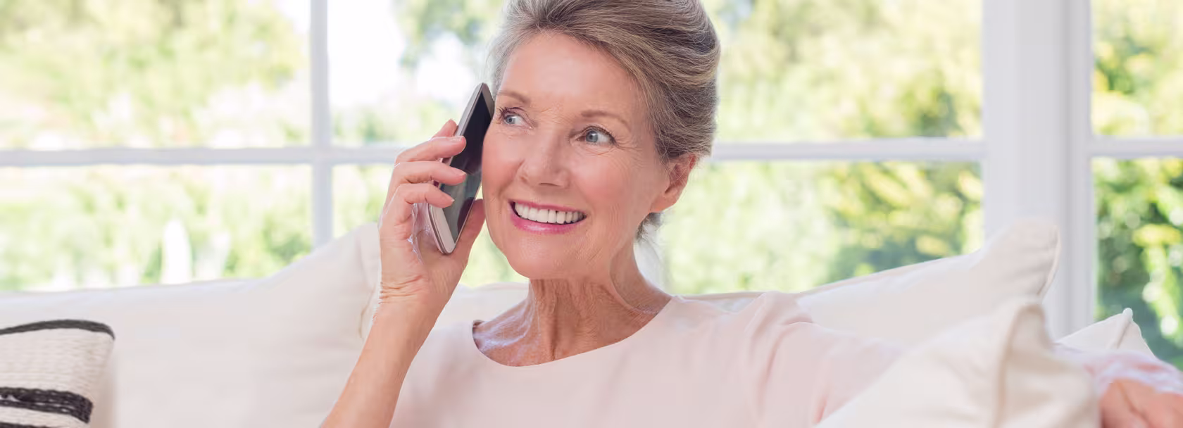Kobieta na kanapie rozmawia przez telefon