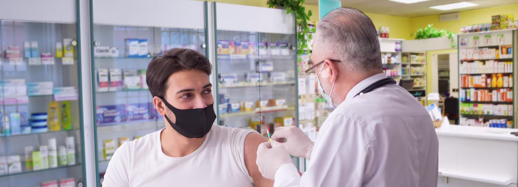 młody mężczyzna jest szczepiony przez farmaceutę