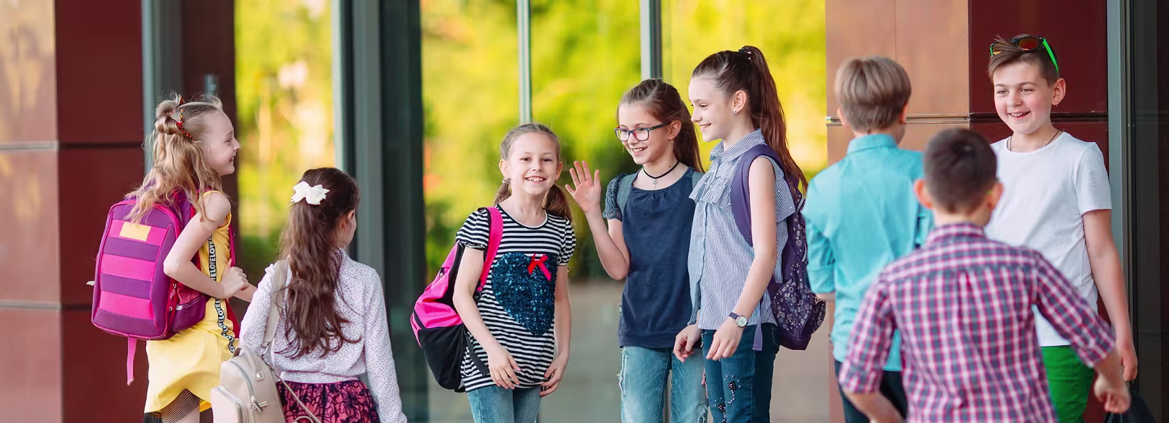 Grupa dzieci wita się przed szkołą