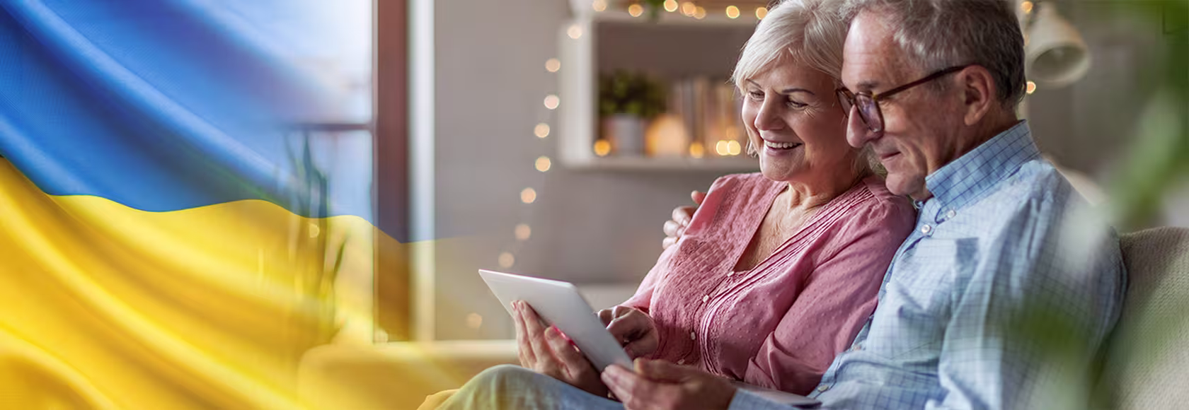 Starsza para na kanapie patrzy na tablet ukr